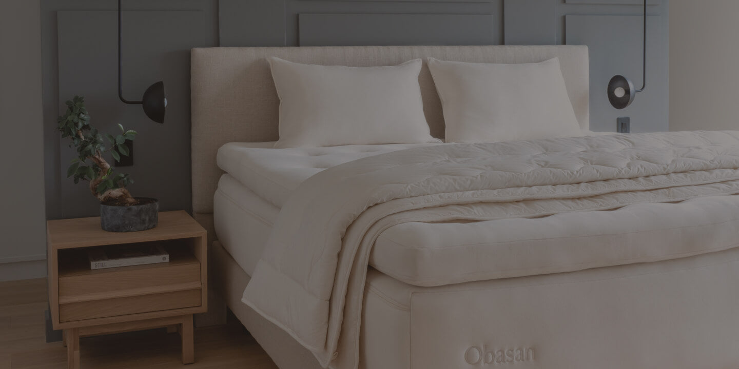 Queen mattress with two pillows and a comforter in a cozy bedroom
